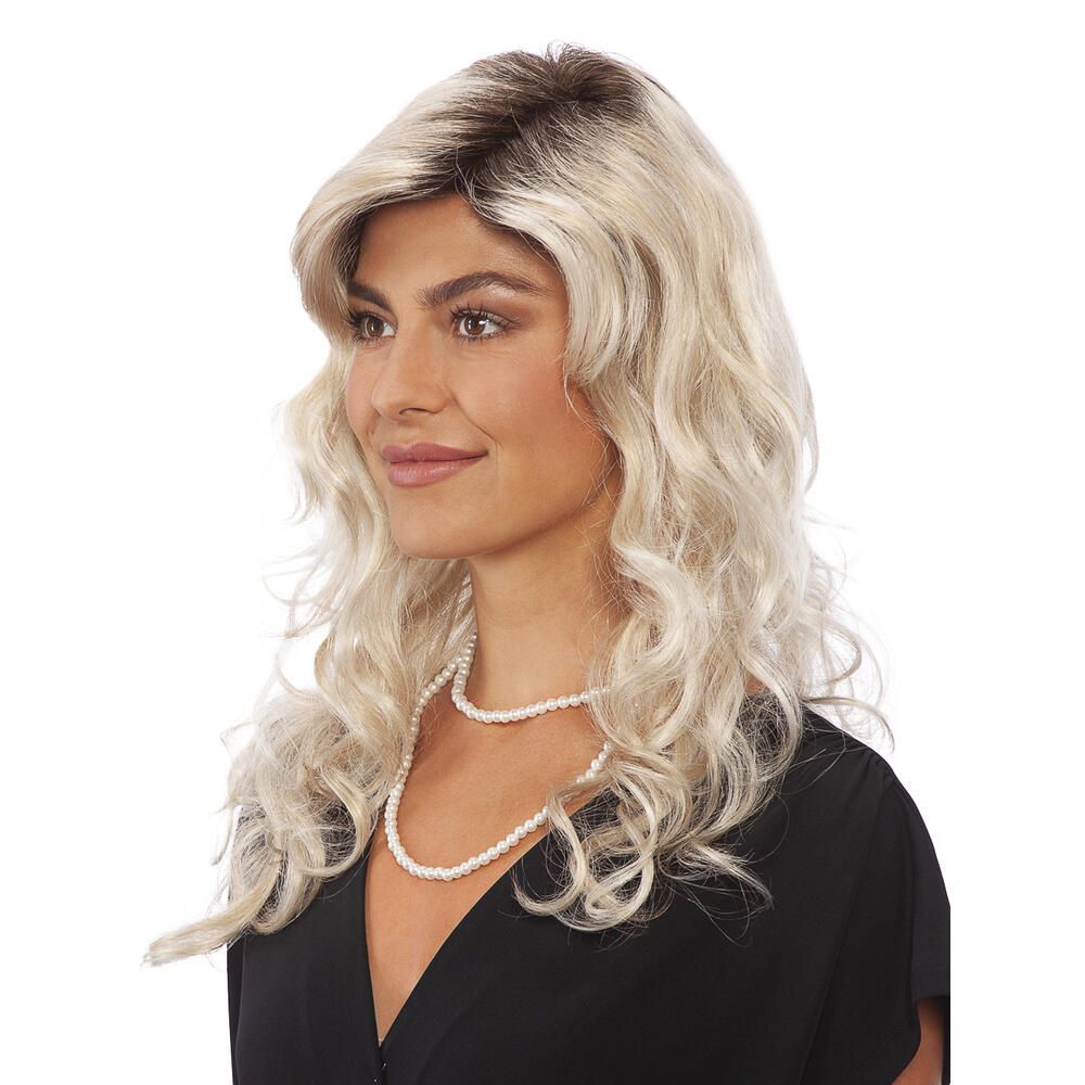 Blond gelockte Perücke mit dunklem Ansatz. Die Frau trägt eine schwarze Bluse und eine Perlenkette.