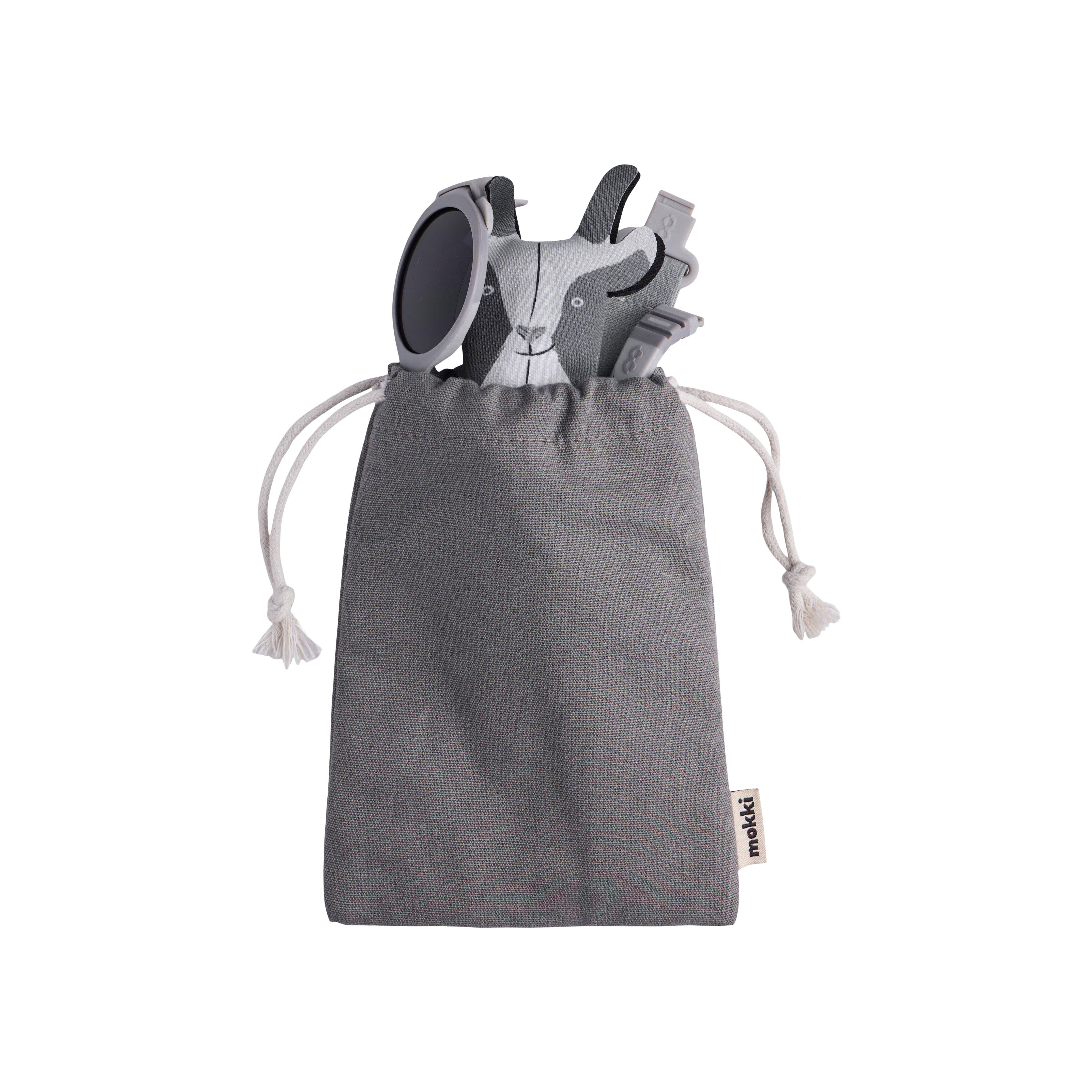 Grauer Beutel mit Sonnenbrille, Zubehör und Ziegen-Etui. Aufschrift: mokki.