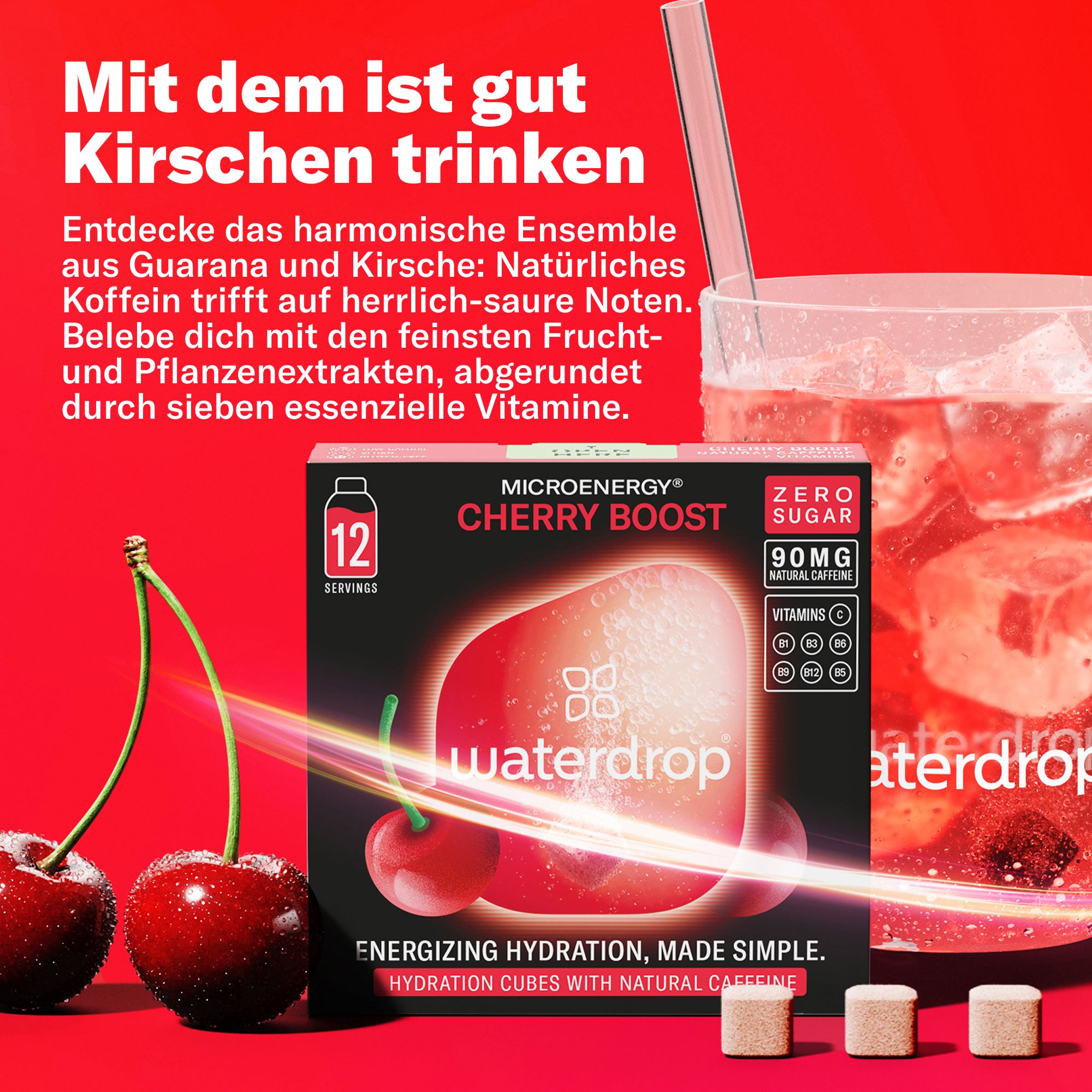 Eine Packung Kirsch-Boost-Würfel mit 12 Portionen. Daneben ein Glas Getränk, Kirschen und drei Würfel. Text: Natürliches Koffein, Guarana, Kirsche.