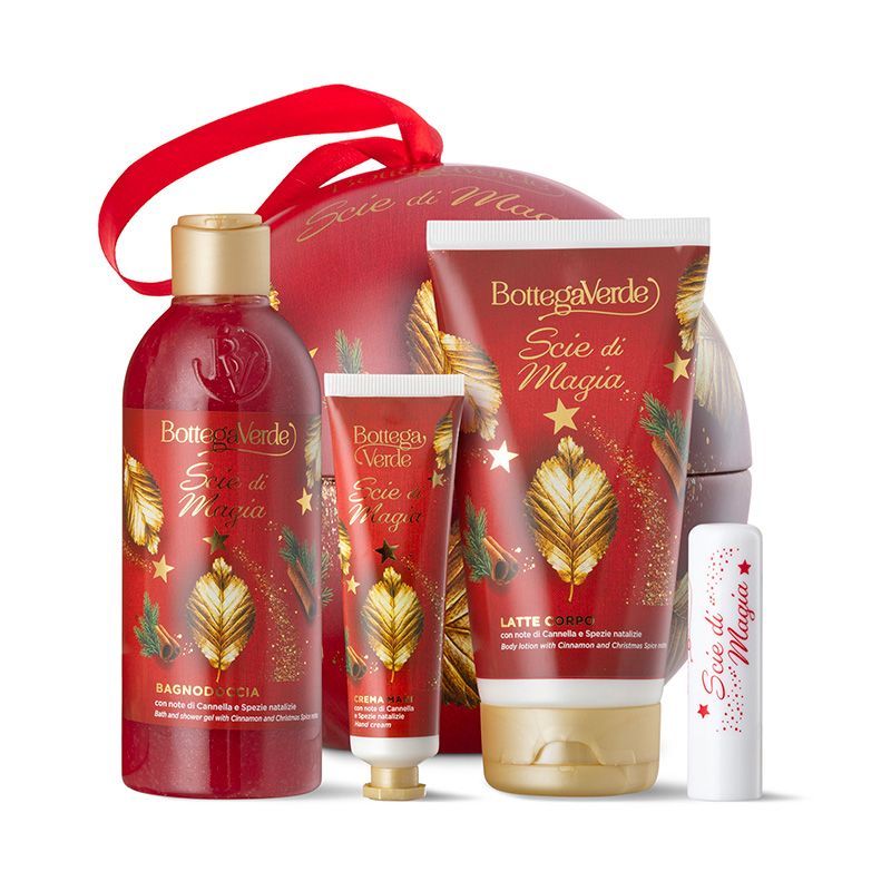 Un set regalo natalizio Bottega Verde, 'Scie di Magia'. Include un packaging rosso a forma di sfera con prodotti come bagnoschiuma, crema mani, latte corpo e balsamo labbra. I prodotti sono in rosso e oro, decorati con motivi natalizi. La confezione ha un manico rosso.