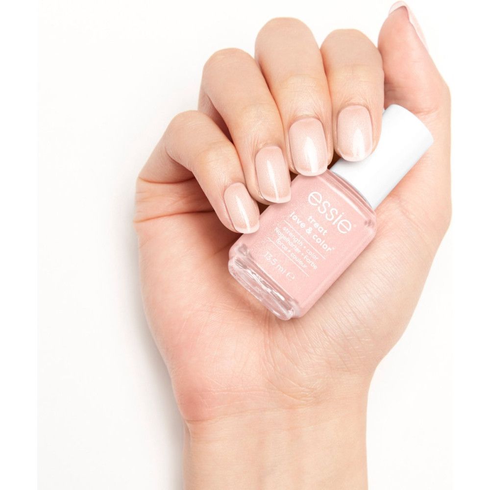 Hand mit lackierten Nägeln. Essie Treat Love & Color Nagellack in rosa. Weißer Hintergrund.