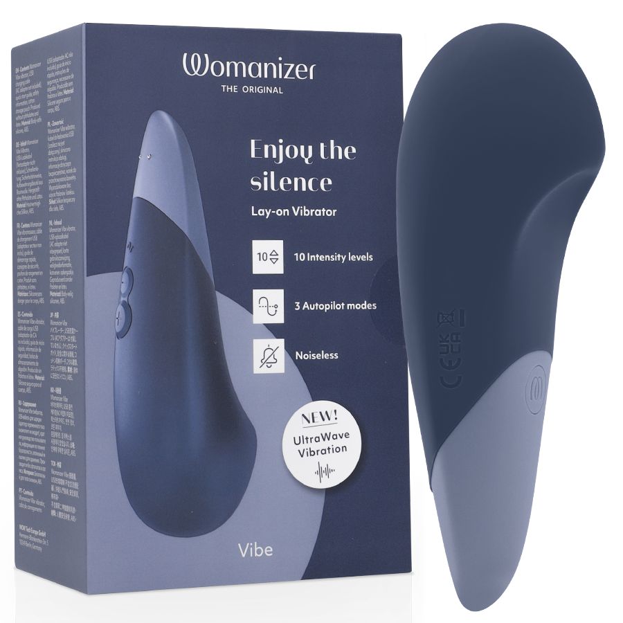 Dunkelblaues Vibrationsgerät mit hellblauem Akzent, neben der Verpackung. Verpackung mit Produktabbildung und Text: Womanizer, Enjoy the silence.