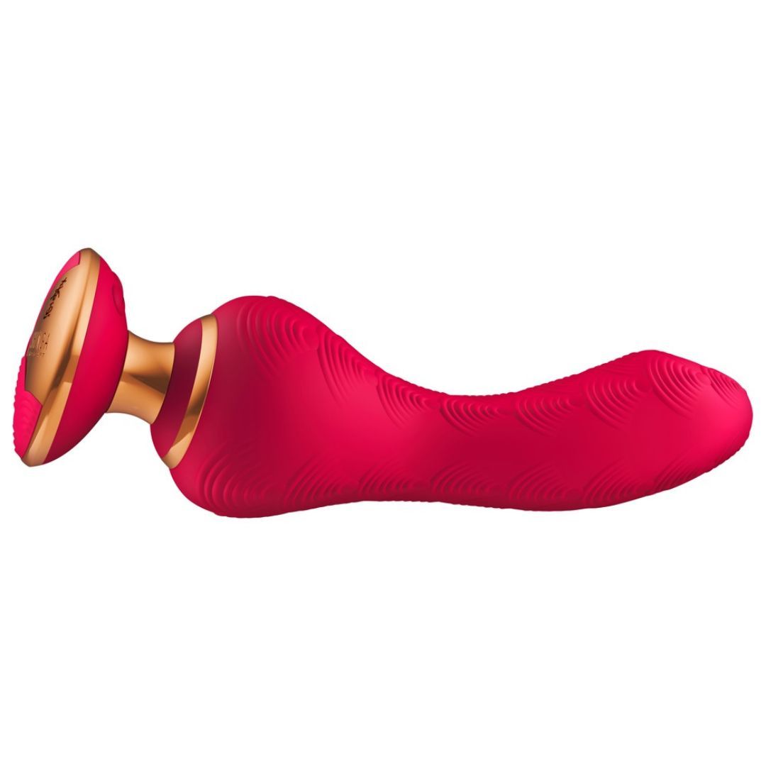 Roter Vibrator mit goldfarbenem Fuß. Oberfläche mit Muster. Liegende Position.