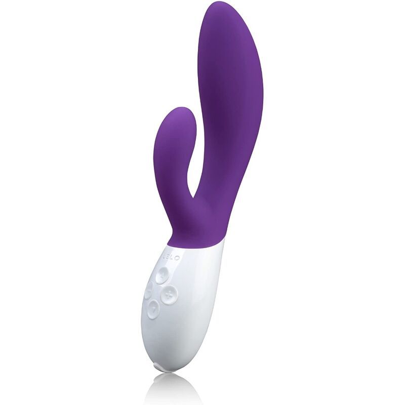 Lila-weißer Vibrator. Zwei gebogene Enden, ein länglicher Schaft. Glatte Oberfläche. Weiße Basis mit Knöpfen.
