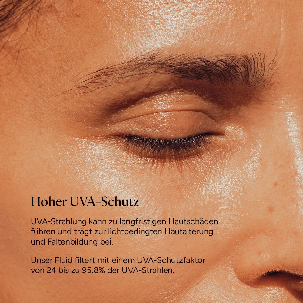 Nahaufnahme eines Auges, das sich auf die Haut konzentriert, mit Sonnenfluid.