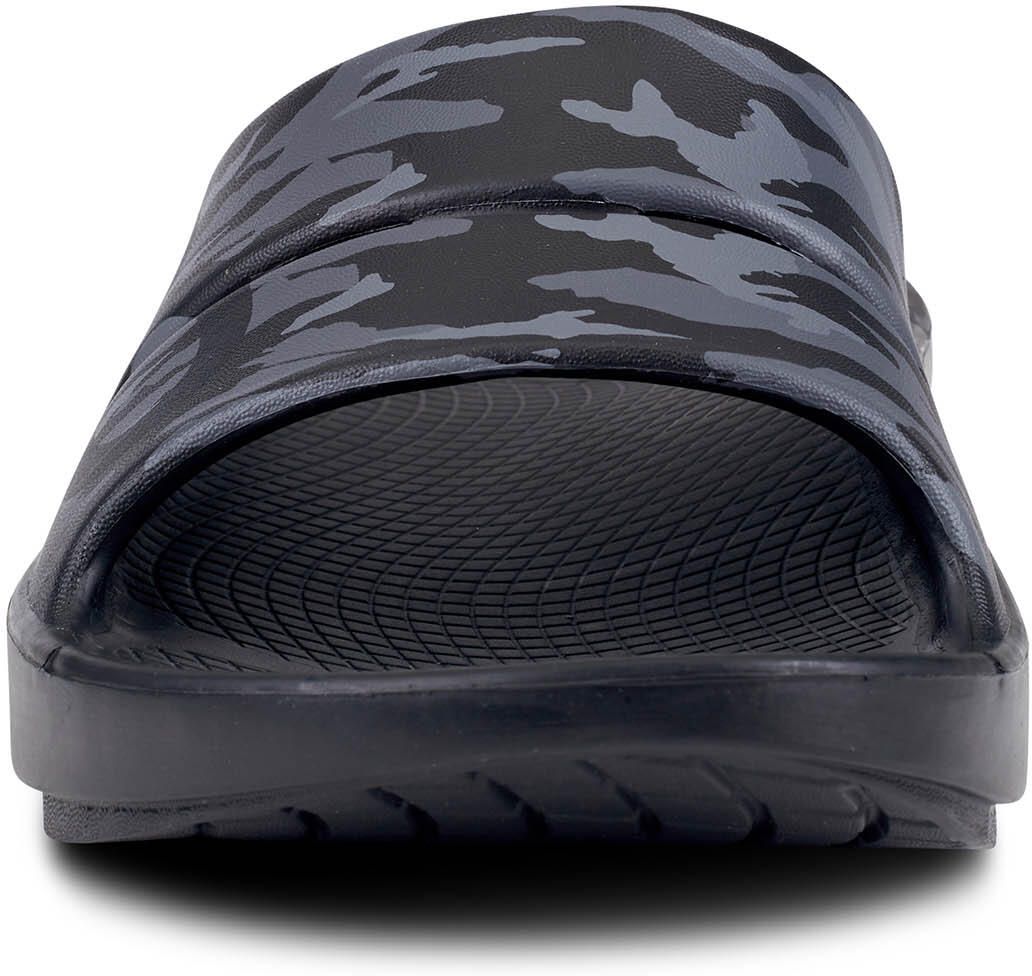 Schwarze Sandale mit Camouflage-Muster. Frontansicht. OOFOS-Logo nicht sichtbar. Dicke Sohle.