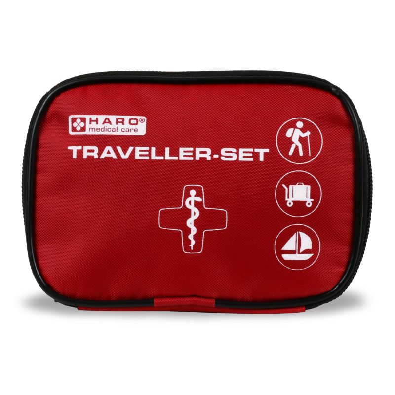 Trousse de premiers secours rouge avec fermeture éclair noire. Inscription : HARO medical care, Traveller-Set. Symboles : randonneur, valise, voilier.