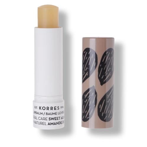 KORRES Lipbalm, geöffnet. Weißer Stift mit sichtbarem Balsam. Braune Hülse mit schwarzen Mandel-Mustern. Text.