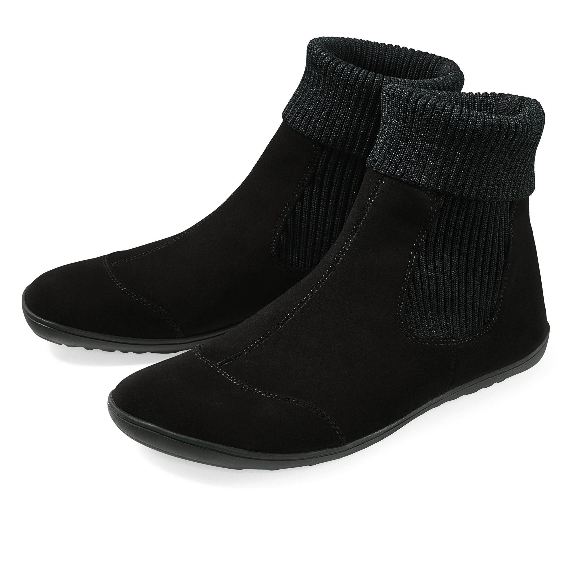 Zwei schwarze Stiefeletten mit geripptem Schaft. Flache Sohle, aus Wildleder. Schuhe nebeneinander.