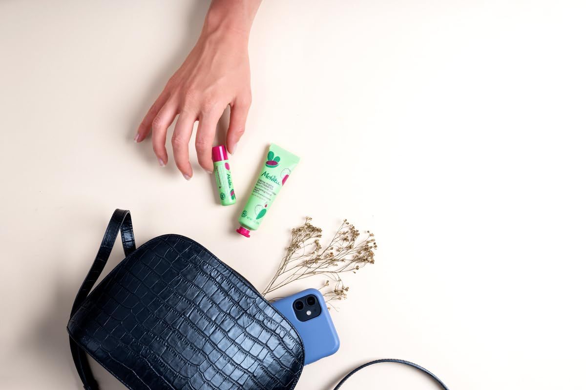 Hand mit Kosmetikprodukten. Handtasche, Lippenbalsam, Creme, Handy. Grünes und rosa Design.