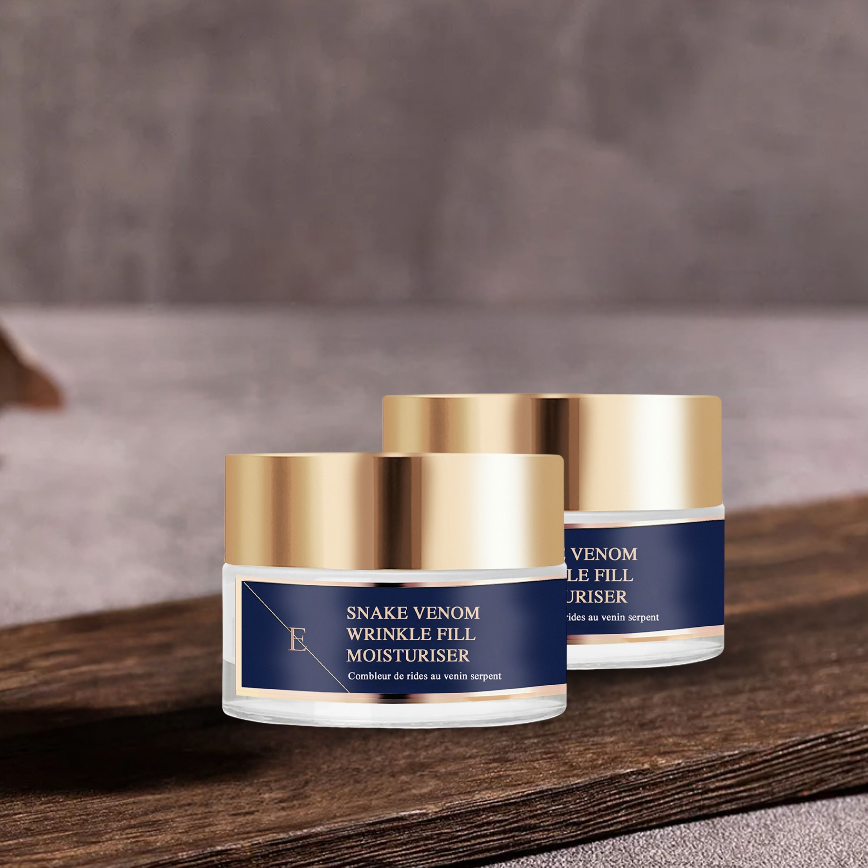 Zwei Tiegel mit goldfarbenen Deckeln und blauen Etiketten. Aufschrift: Snake Venom Wrinkle Fill Moisturiser.