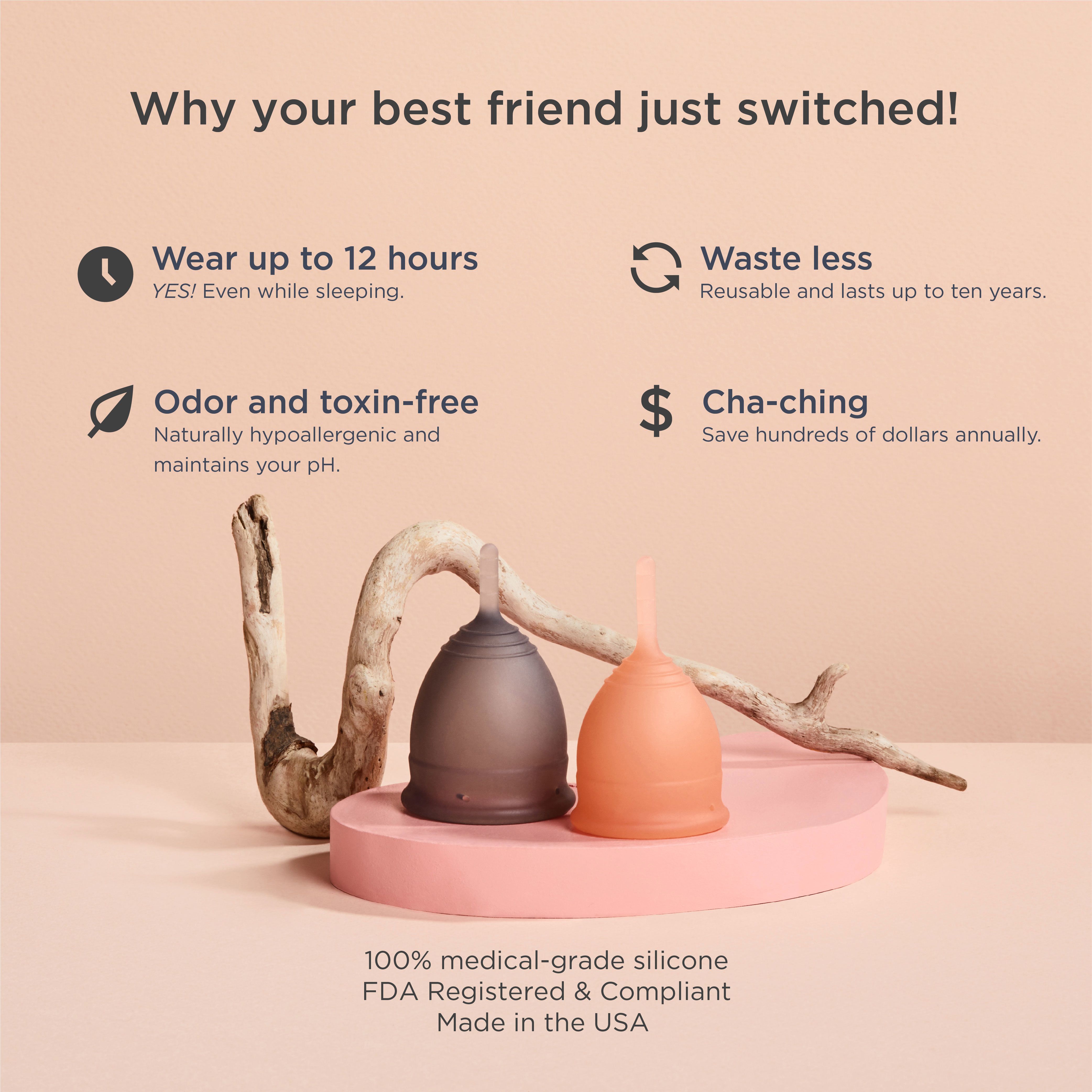 Zwei Menstruationstassen, eine grau, eine pfirsichfarben. Auf rosa Podest mit Zweig. Text: 100% medizinisches Silikon, FDA-registriert.