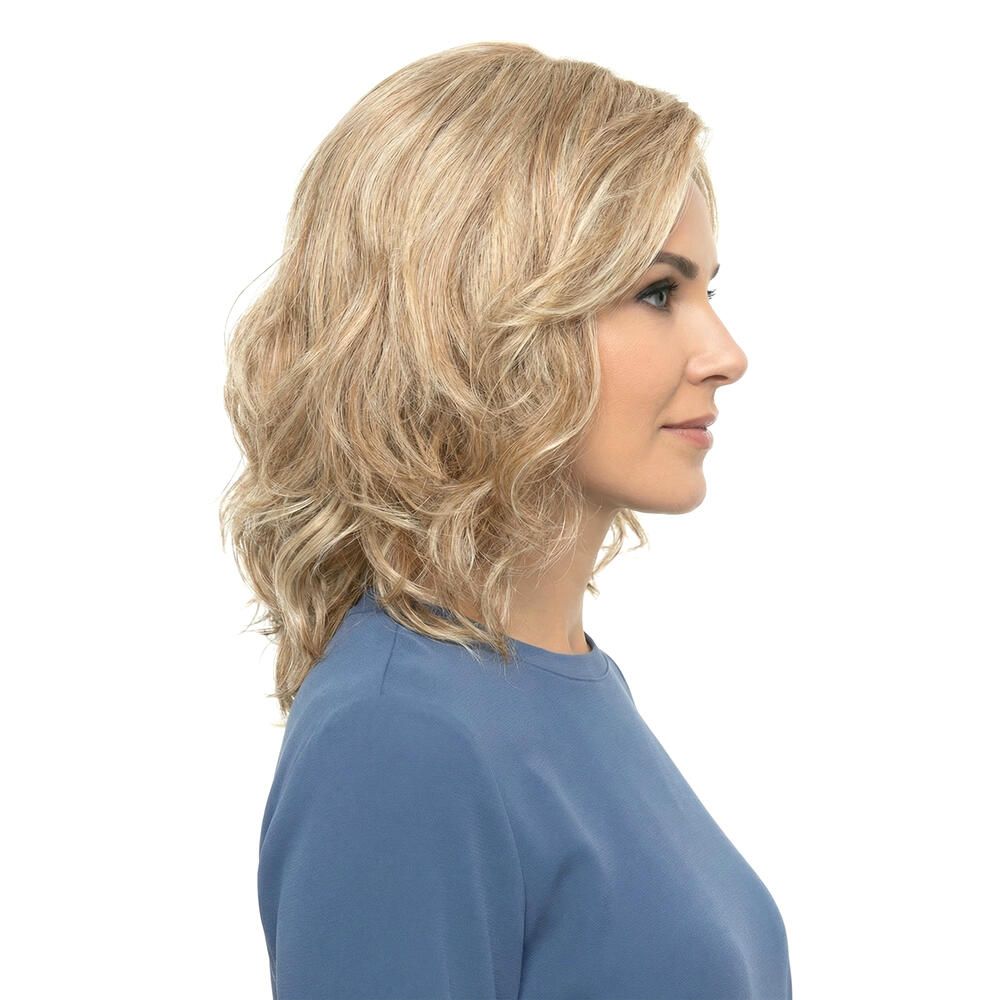 Frau mit blond gewellter Perücke. Seitenansicht. Die Perücke hat blonde und hellbraune Strähnen.