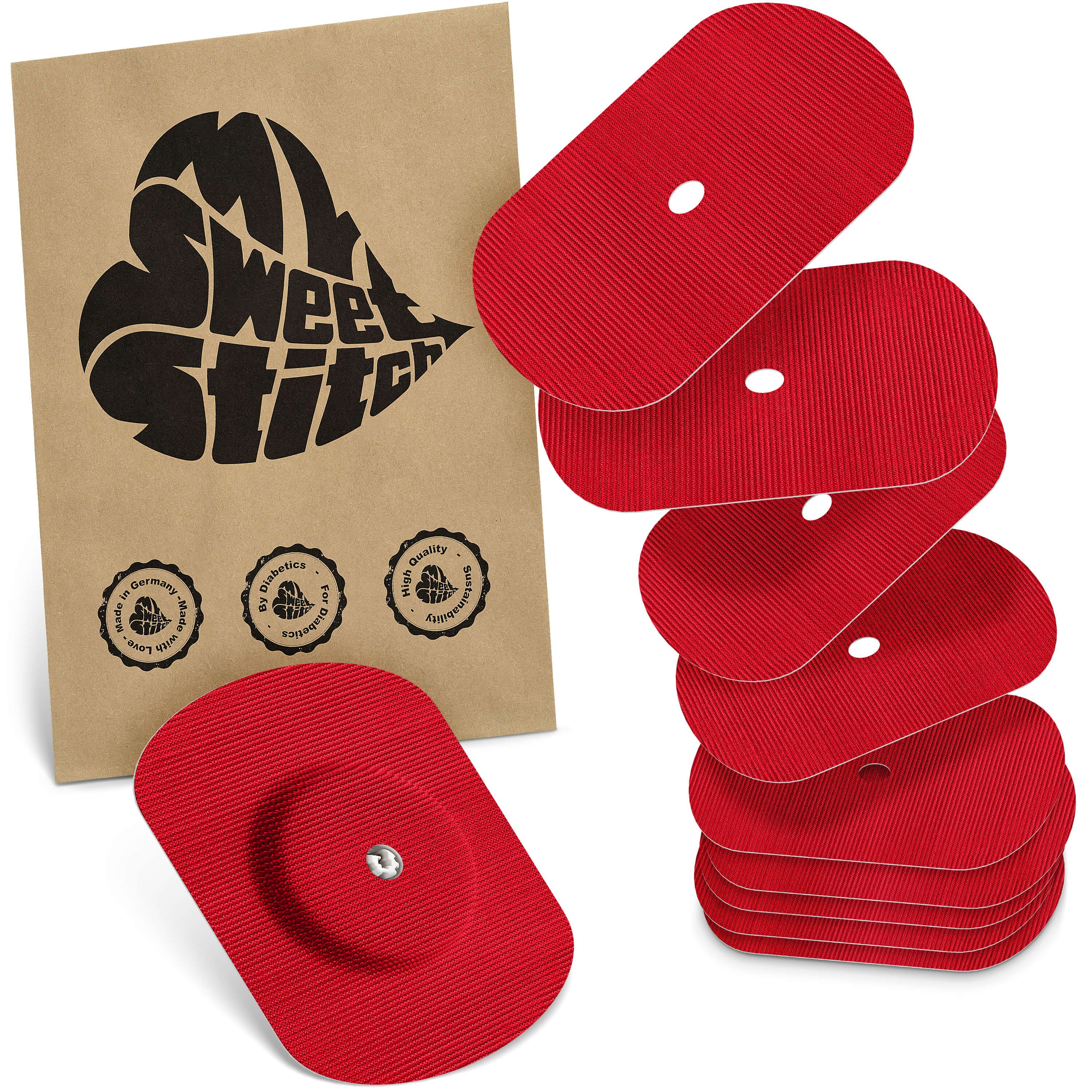 Rote ovale Aufkleber für Freestyle Libre 1 & 2, ein Aufkleber mit Sensor, daneben ein Stapel von fünf Aufklebern und eine braune Papiertüte mit Logo.