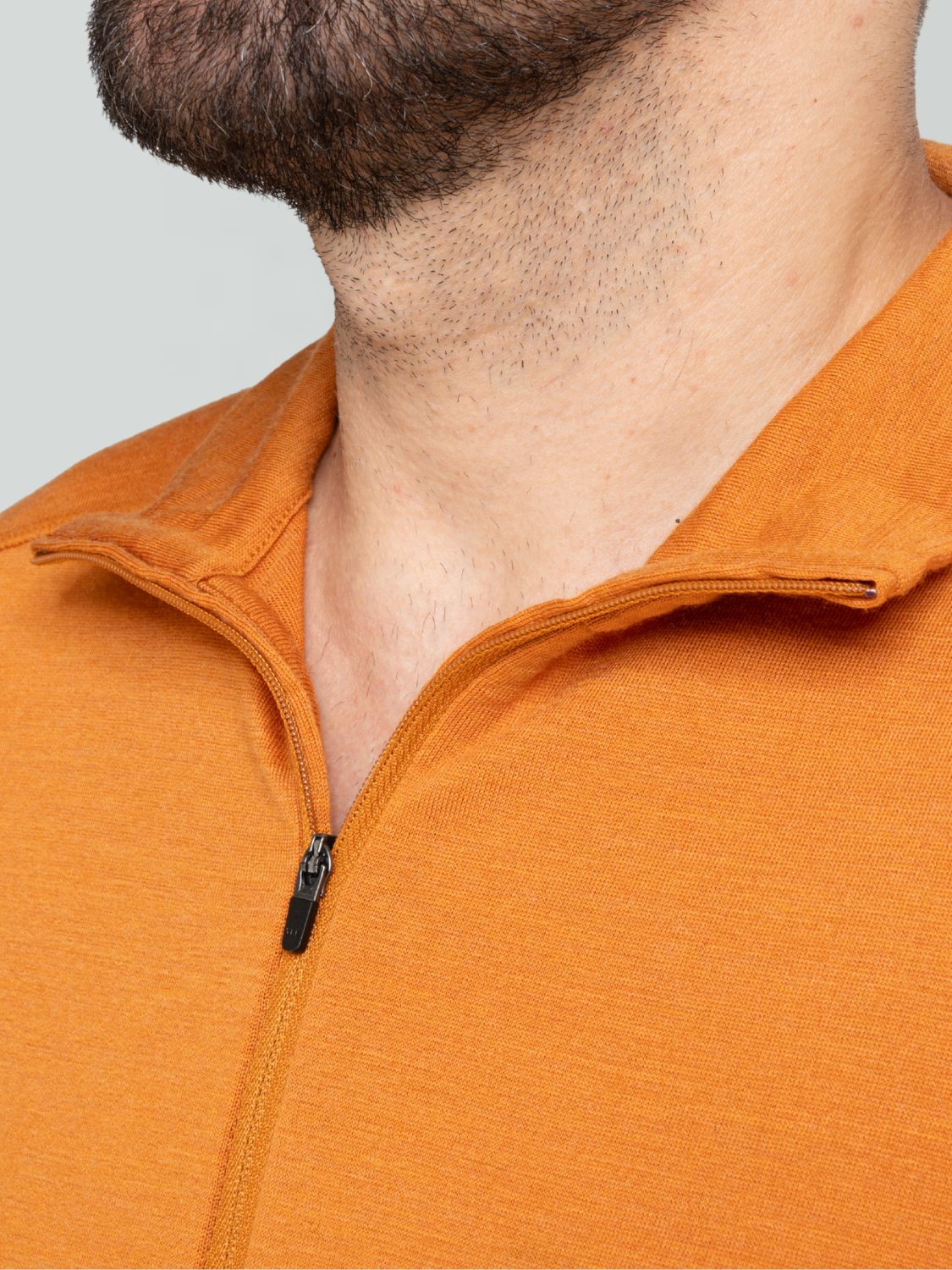 Orangefarbener Herren-Merino-Pullover mit Reißverschluss am Kragen.