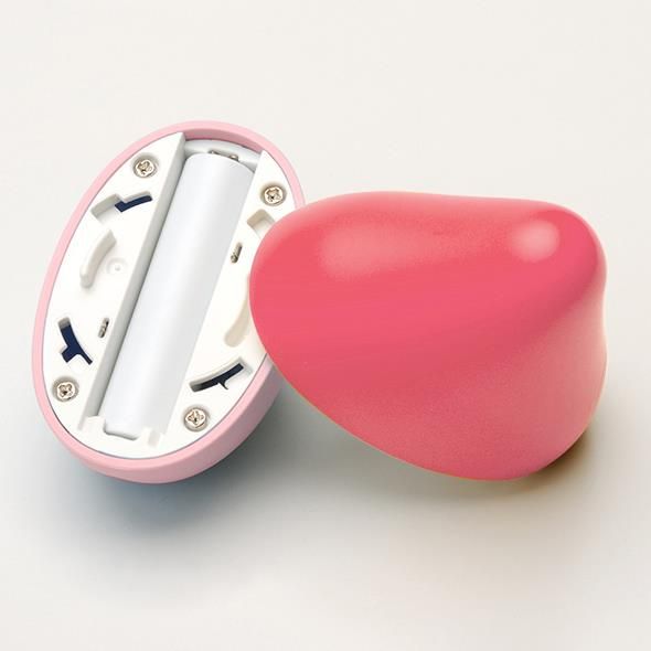 Rosa Objekt, geöffnet. Innenraum mit Batteriefach und Schrauben. Eine Batterie ist sichtbar.