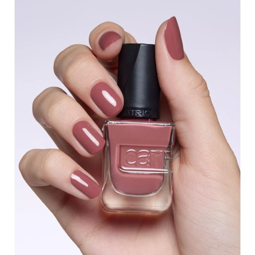 Hand mit lackierten Nägeln und Nagellackflasche. Der Nagellack ist rosa. Der Markenname Catrice ist sichtbar.