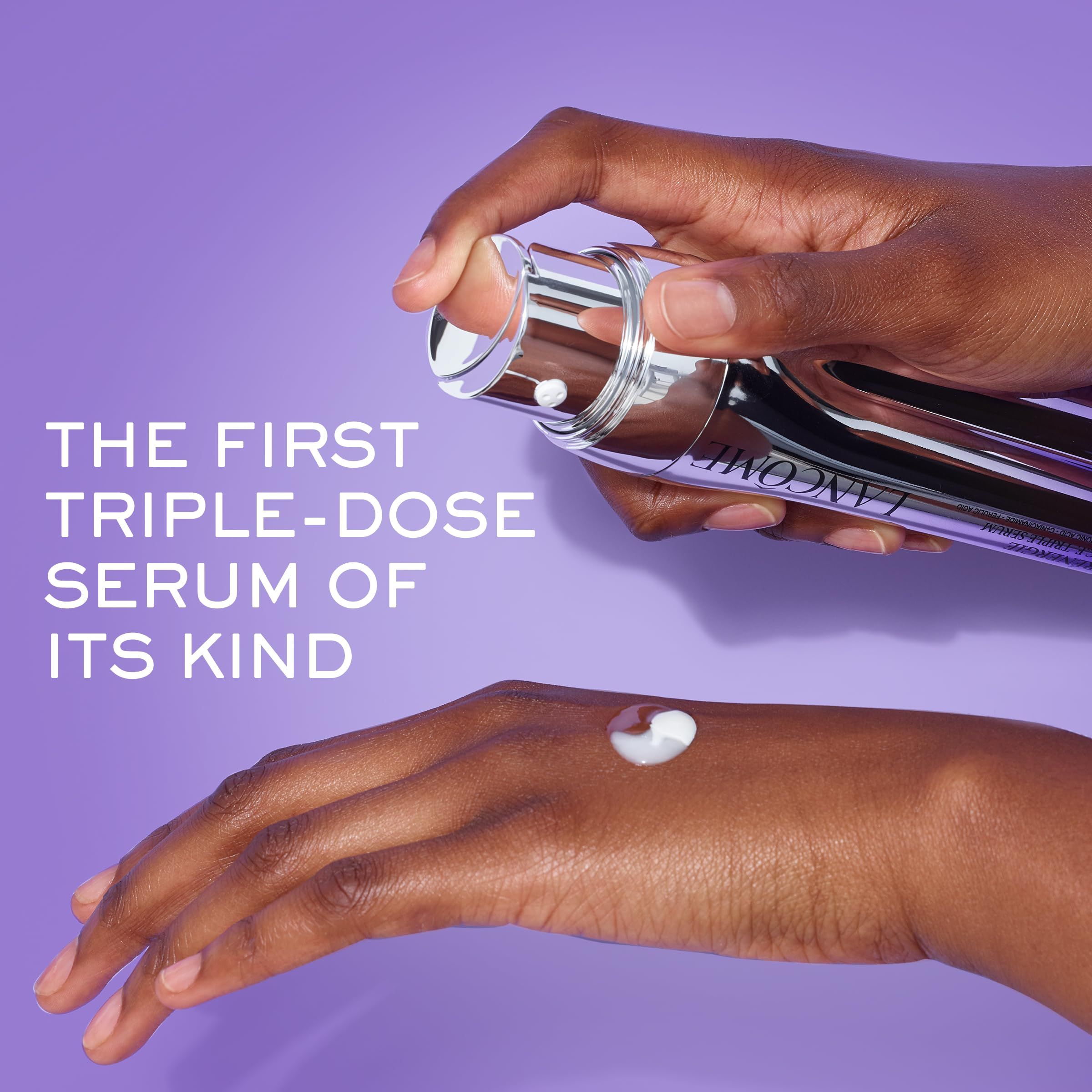 Hände halten eine Serumflasche. Aufschrift: Lancôme. Text: The first triple-dose serum of its kind. Serum wird auf die Hand aufgetragen.