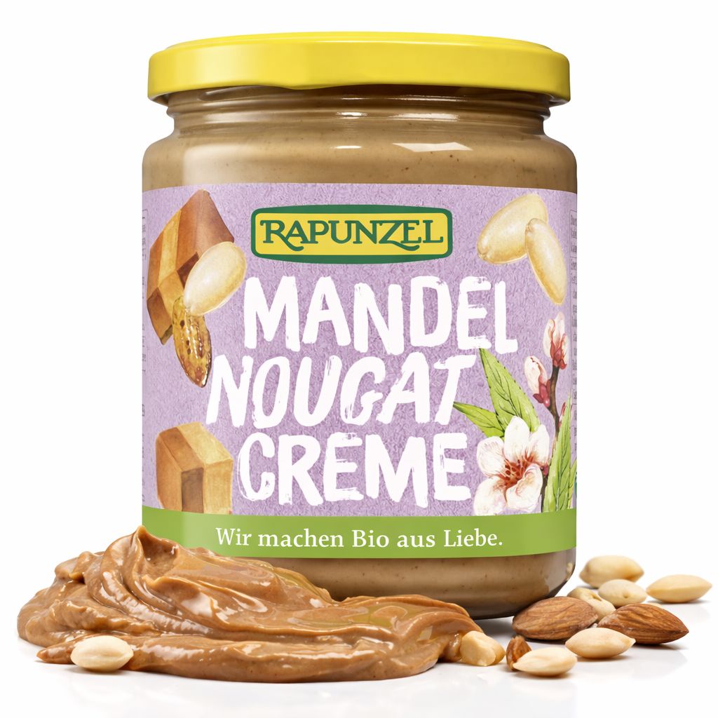 Rapunzel Mandel-Nougat-Creme im Glas, mit einem Berg von Creme daneben. Mandeln und Erdbeeren sind um das Glas verteilt.