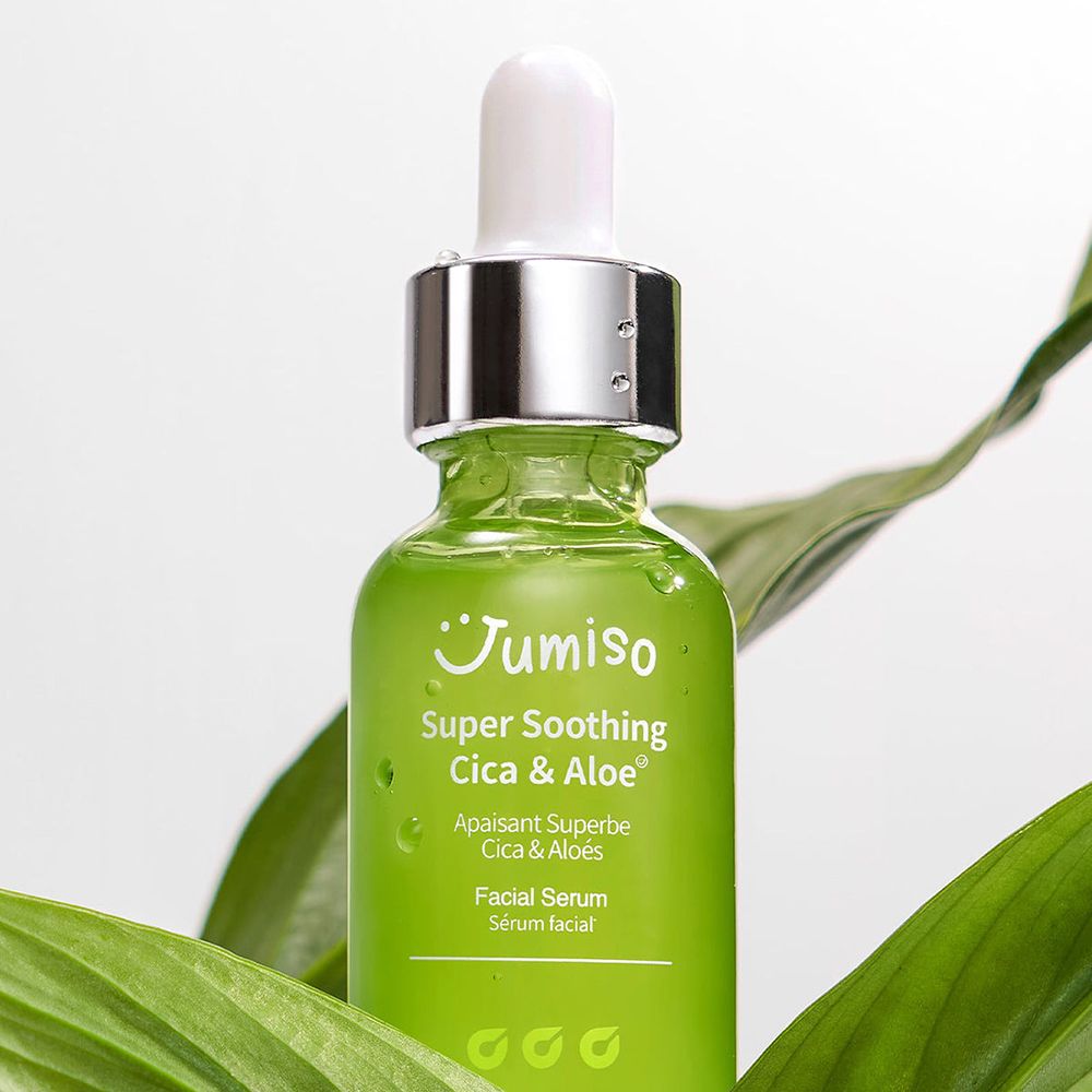 Grüne Glasflasche mit weißem Deckel und Pipette, umgeben von grünen Blättern. Aufschrift: Super Soothing Cica & Aloe.