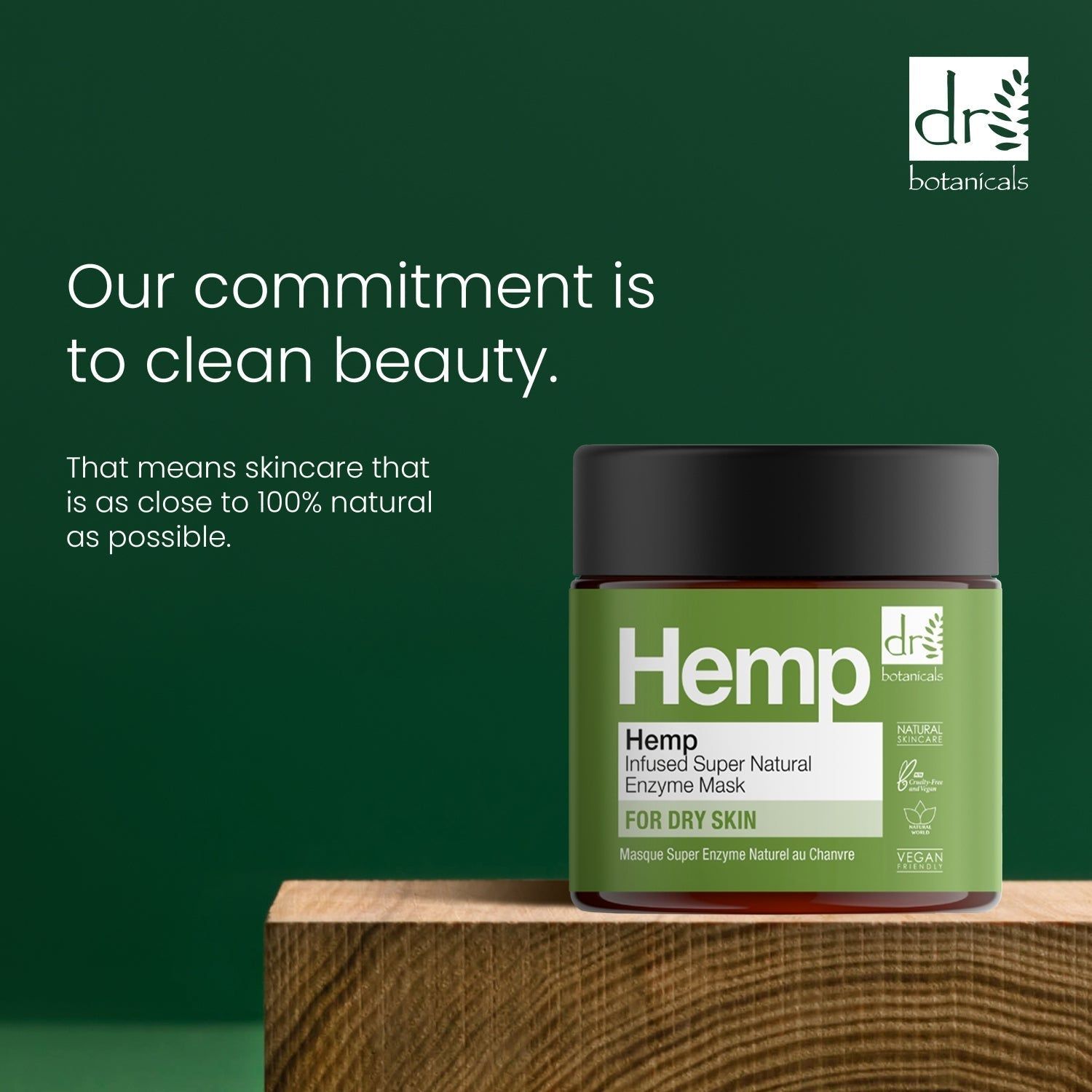 Grünes Glas auf Holzblock. Text: Our commitment is to clean beauty. Skincare that is as close to 100% natural as possible.