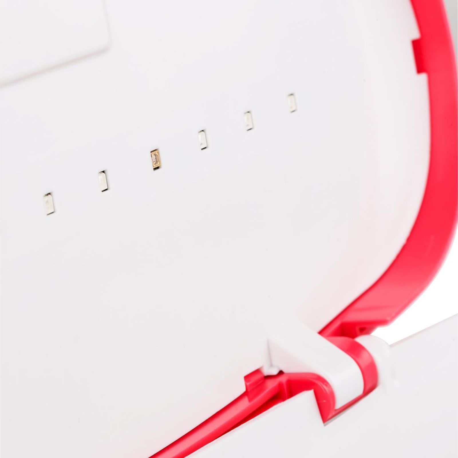 Nahaufnahme der geöffneten Box. UV-Lichter im Deckel. Roter Deckelrand, weißes Gehäuse.