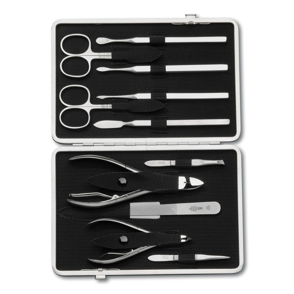 Maniküre-Etui, silberfarbenes Gehäuse, schwarze Innenauskleidung. Enthält Scheren, Feilen, Zangen und weitere Werkzeuge. Geöffnet.