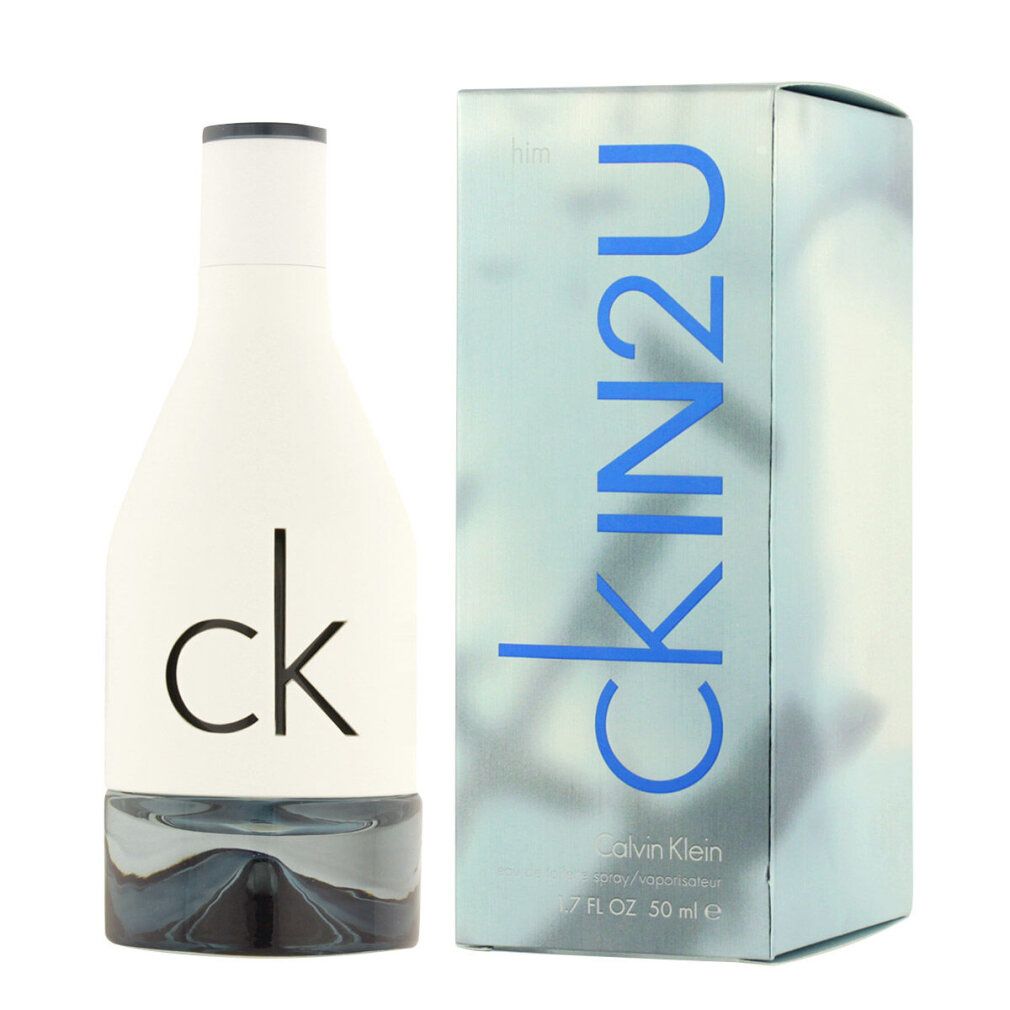 Weißes Parfümflakon und Schachtel. Aufschrift: ck IN2U, him. Flakon mit silberfarbenem Boden. Schachtel mit blauem Schriftzug.