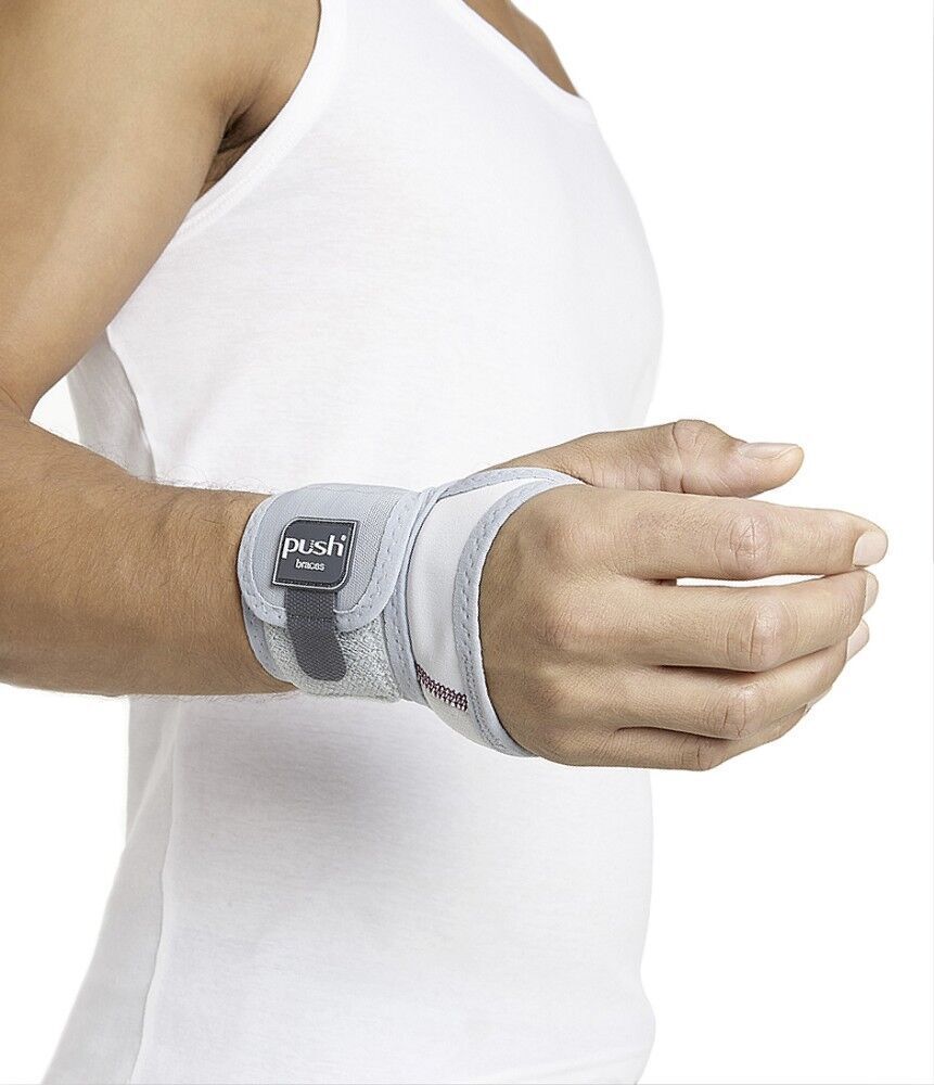 Person trägt graue Handgelenkbandage. Push-Braces-Logo sichtbar. Klettverschluss. Weißes Tanktop.