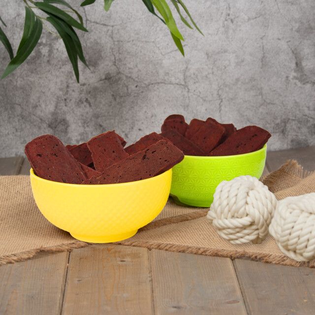 Lammfleischstreifen in gelben und grünen Schalen, auf Leinentuch, mit Dekoration.