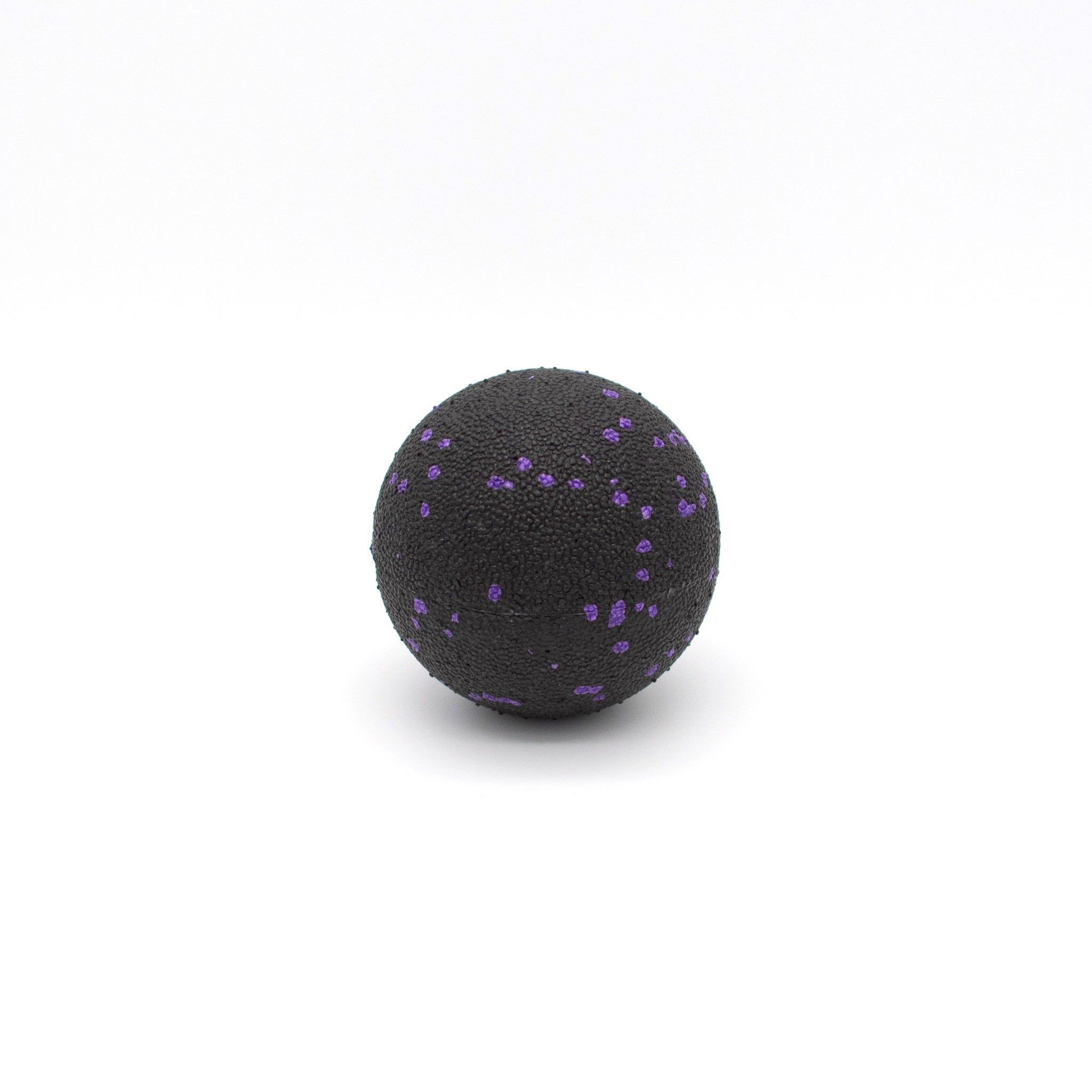 Schwarzer Faszienball mit lila Punkten. Mittlere Härte. 8cm Durchmesser. Auf weißem Hintergrund.