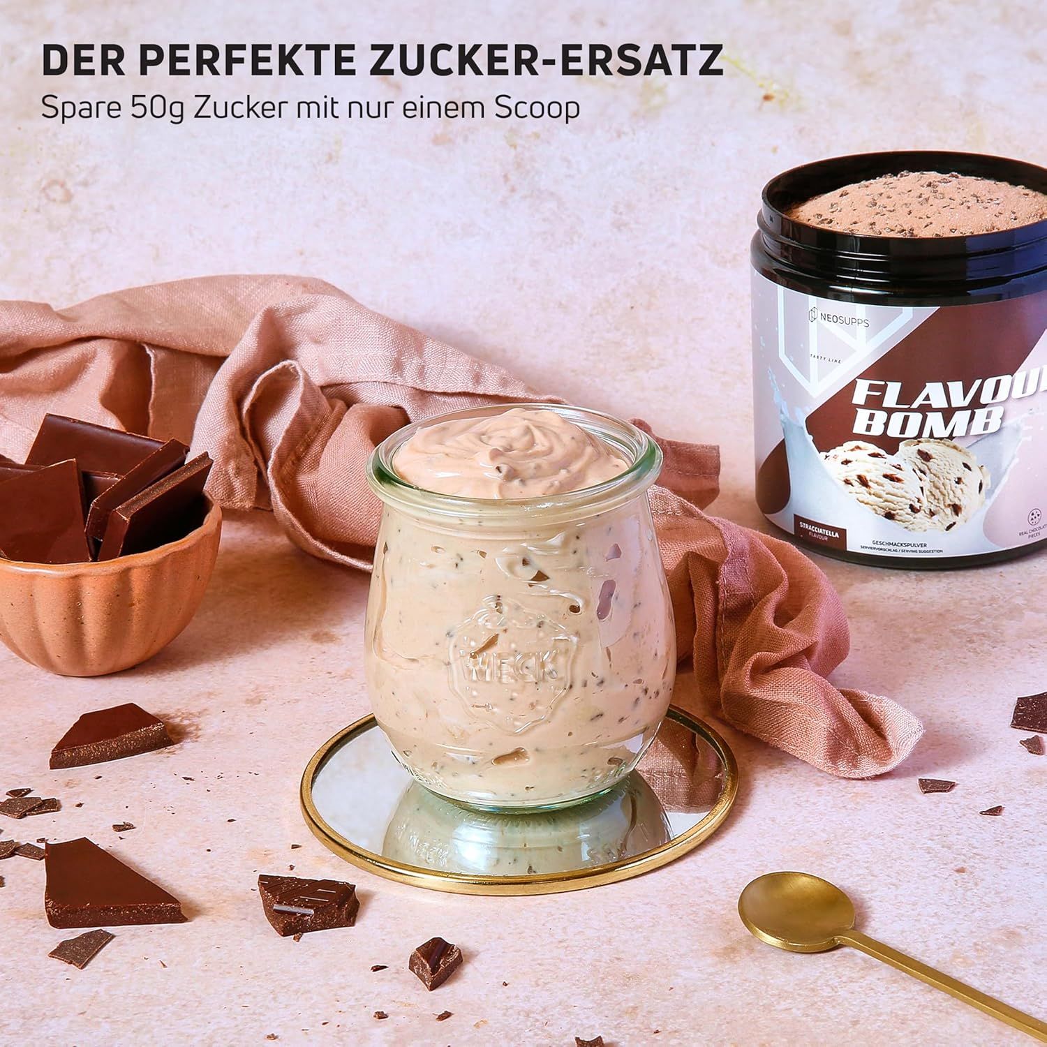Glas mit Creme, Schokoladenstücke, Dose mit FLAVOUR BOMB. Text: DER PERFEKTE ZUCKER-ERSATZ. Spare 50g Zucker mit nur einem Scoop.