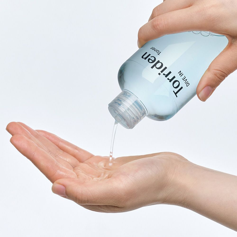 Torriden DIVE IN Toner wird aus einer Flasche in eine Handfläche gegossen.