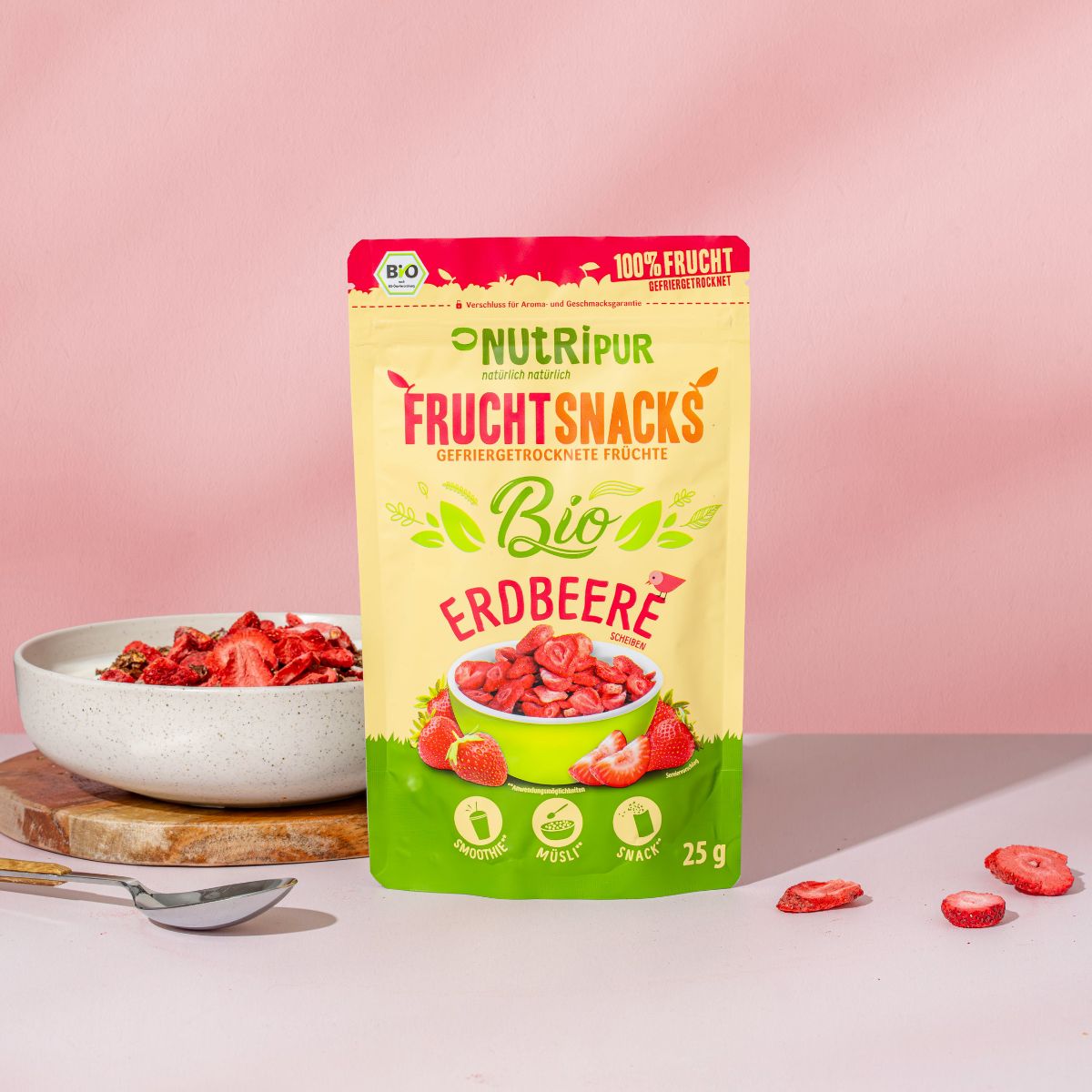 Verpackung NutriPur FruchtSnacks Bio-Erdbeere. Aufschrift: 100% Frucht, Bio, 25g. Erdbeeren und Müsli in Schale.
