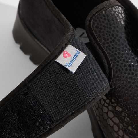 Schwarzer Damenschuh mit Klettverschluss und Schlangenmuster-Akzent.