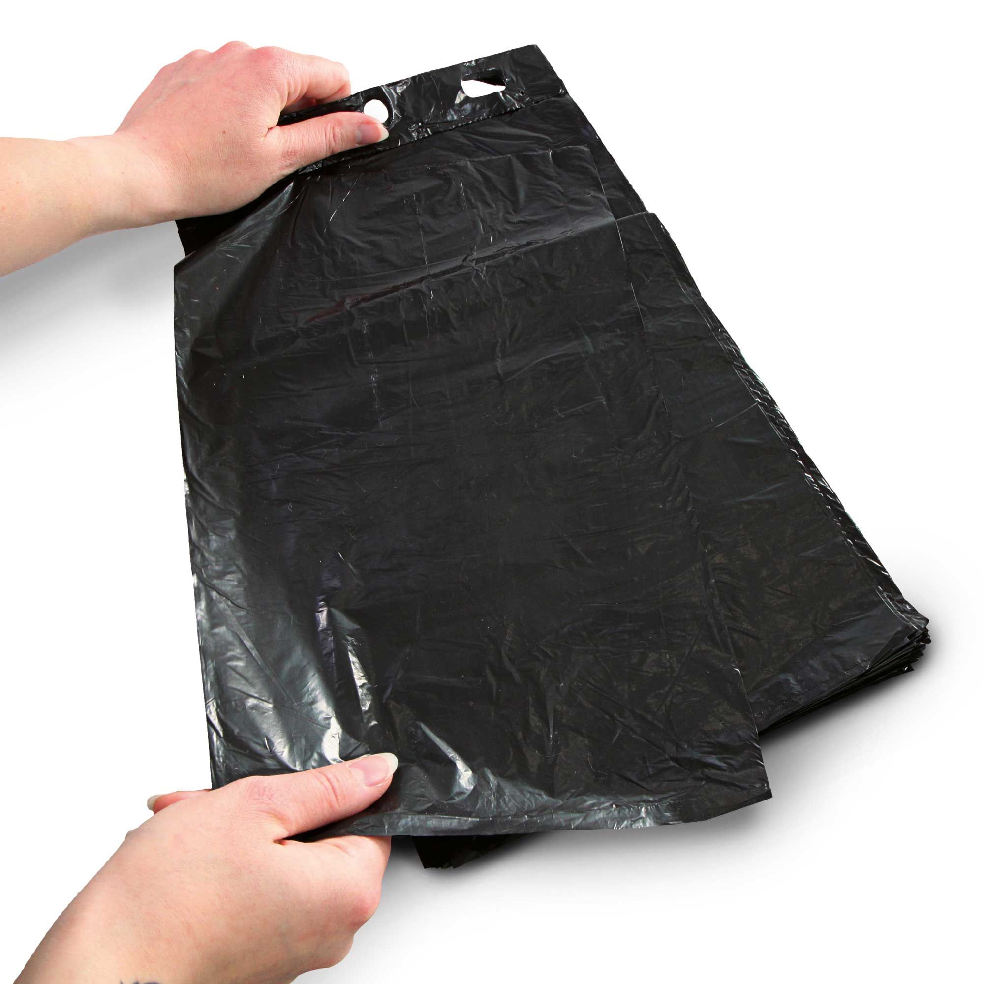 Hände halten flache, schwarze Hundekotbeutel mit Lochung zum Öffnen.