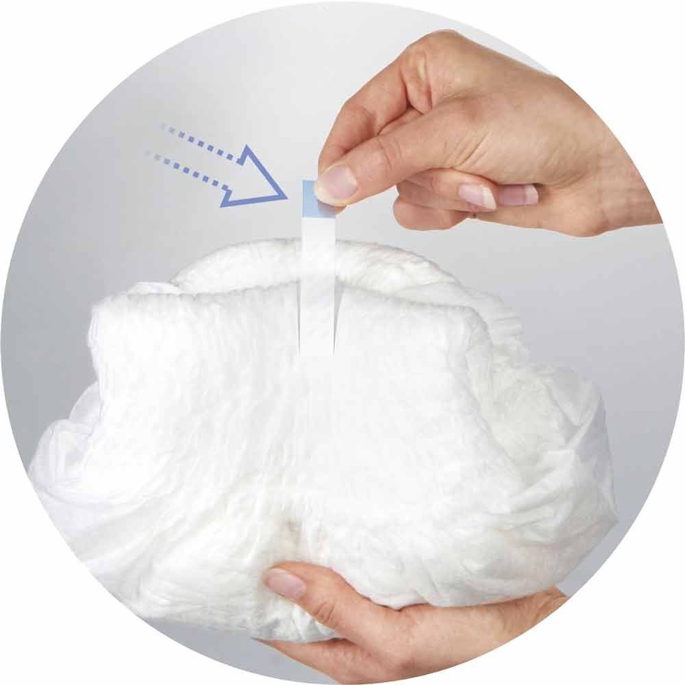 Nahaufnahme einer Person, die die Klebestreifen an einer Seni Active Super Inkontinenzhose öffnet.