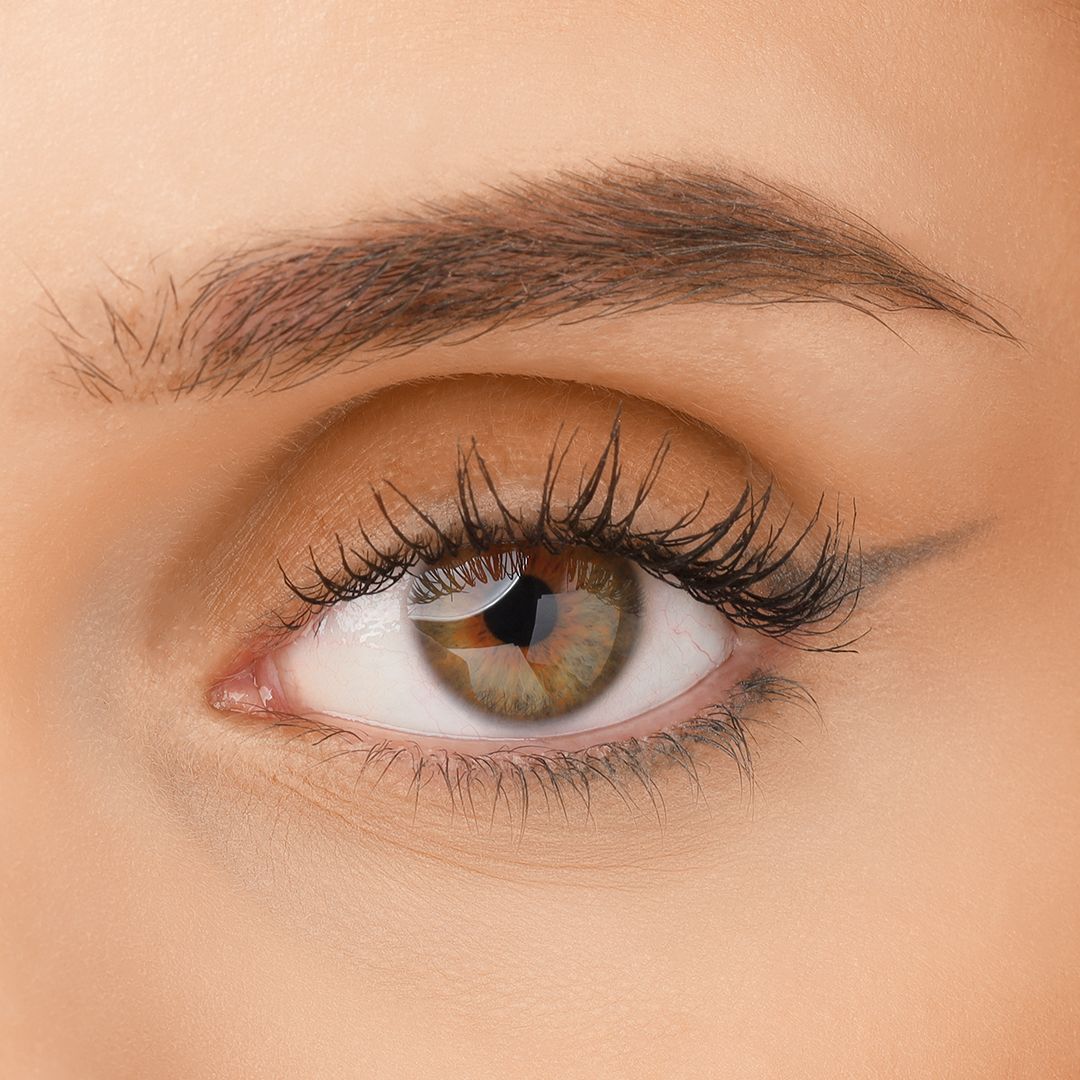 Auge mit getuschten Wimpern. Braune Augenbraue. Schwarzer Lidstrich. Grünes Auge.