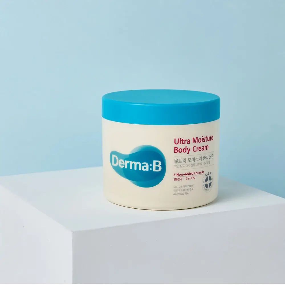 Behälter mit blauem Deckel. Aufschrift "Derma:B Ultra Moisture Body Cream". Logo und Text in mehreren Sprachen.