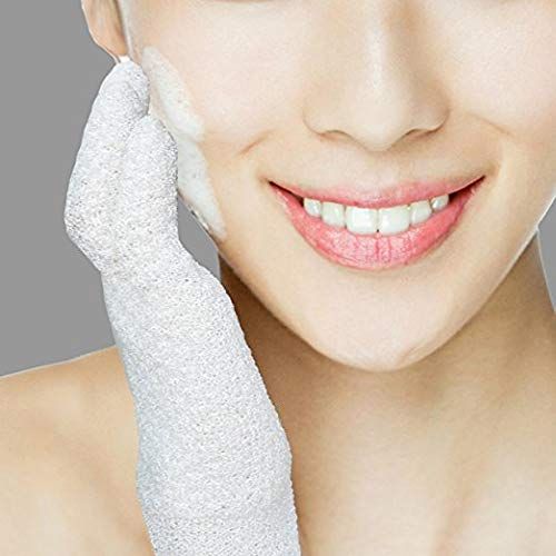 Eine Person benutzt einen weißen Peeling-Handschuh, um ihr Gesicht mit Schaum zu reinigen.