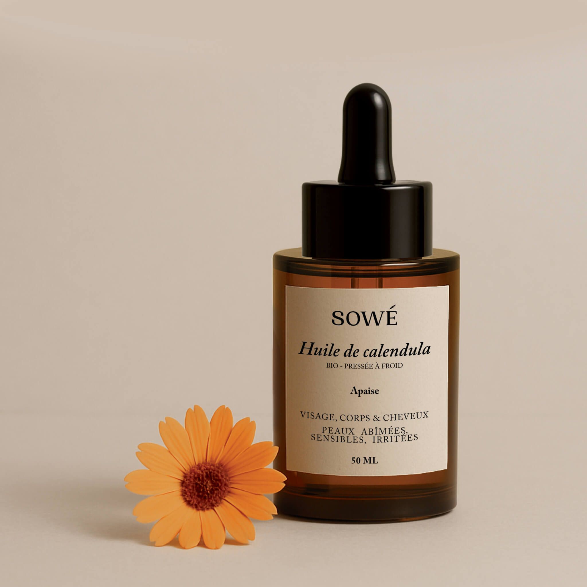 Braune Glasflasche mit Pipette und gelber Flüssigkeit. Etikett mit Produktnamen. Orangefarbene Ringelblume daneben.