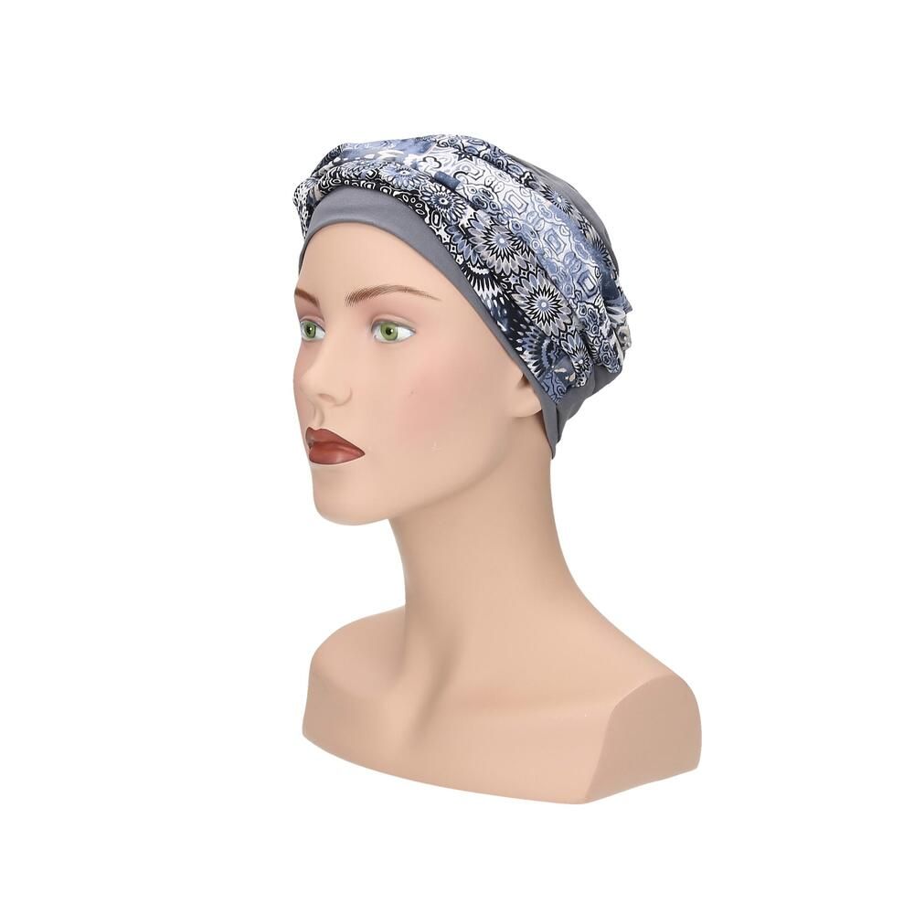 Grauer Turban mit floralem Muster. Auf einem Mannequin präsentiert. Seitenansicht.