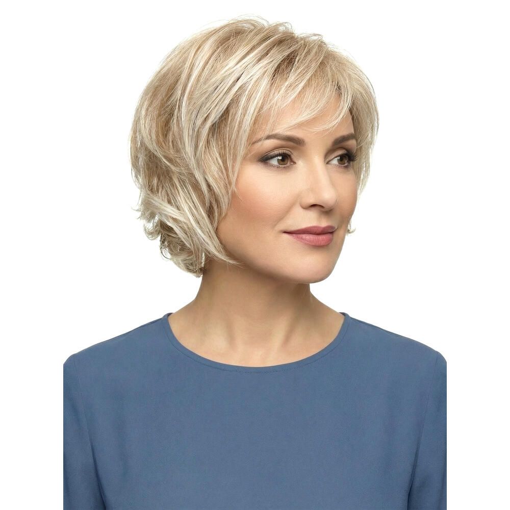 Blond gefärbte Perücke mit kurzem, gewelltem Schnitt. Dreiviertelansicht einer Frau mit blauem Oberteil.