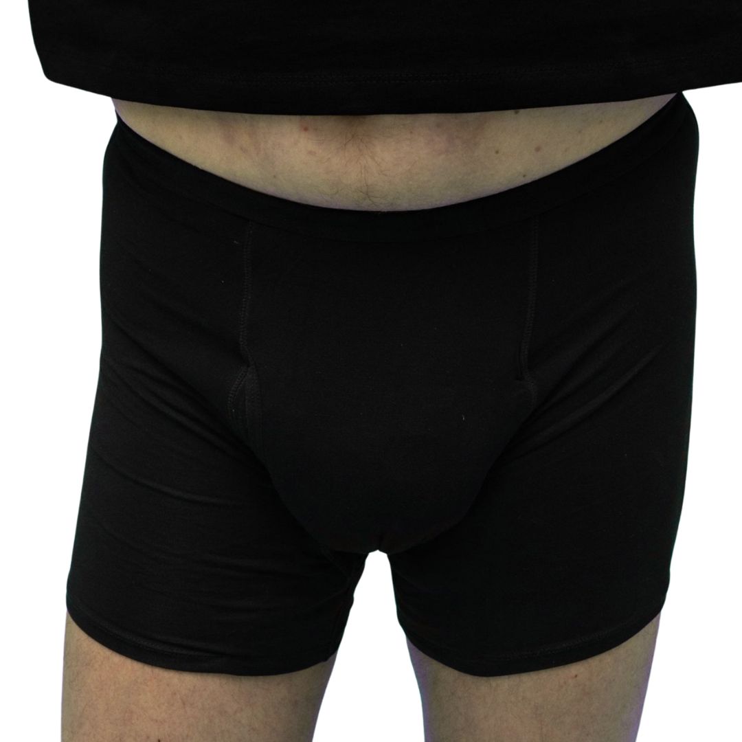 Nahaufnahme: Mann in schwarzer Boxershorts. Elastischer Bund, Stoff mit Faltenwurf.
