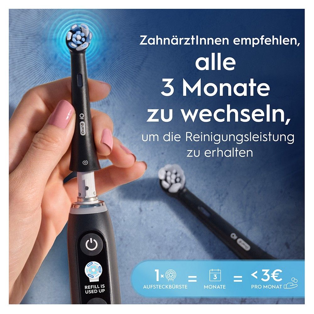 Hand zeigt Oral-B iO Bürstenkopf auf elektrischer Zahnbürste.