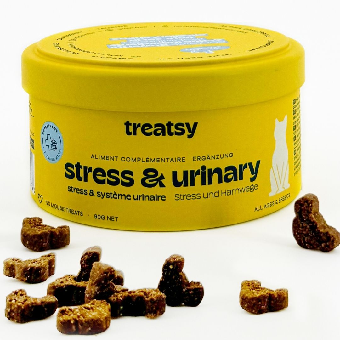 Gelbe Dose mit Aufschrift "treatsy stress & urinary". Braune, mausförmige Snacks liegen daneben.
