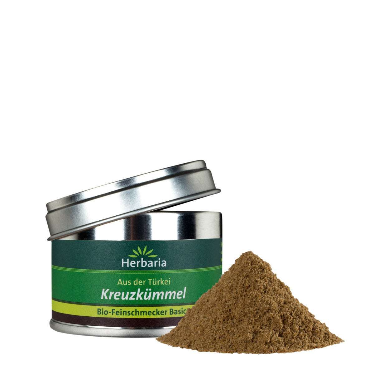 Geöffnete Dose mit Kreuzkümmel, daneben ein Haufen Kreuzkümmel. Dose mit grünem Etikett, Aufschrift Herbaria, Kreuzkümmel, Bio.