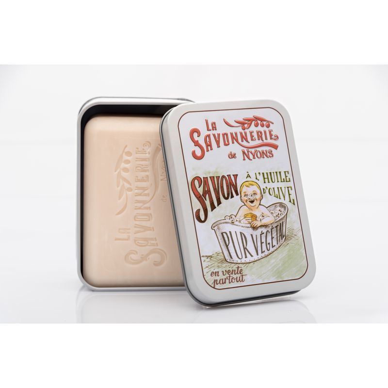 Seife in Metallbox. Box mit Aufdruck: Baby in Badewanne, Schriftzug 'La Savonnerie de Nyons'. Seife liegt daneben.