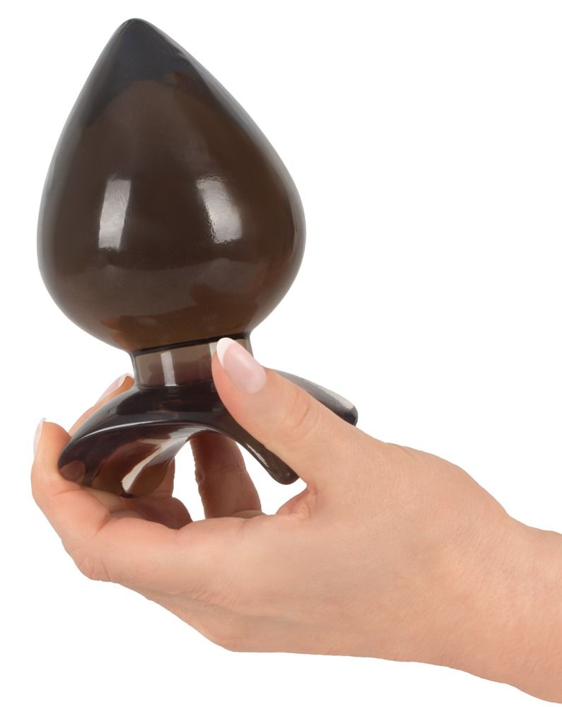 Analplug, braun getönt, Tropfenform. Spitze und Basis dunkler. Glatte Oberfläche. In Hand gehalten. Breiter Basis.