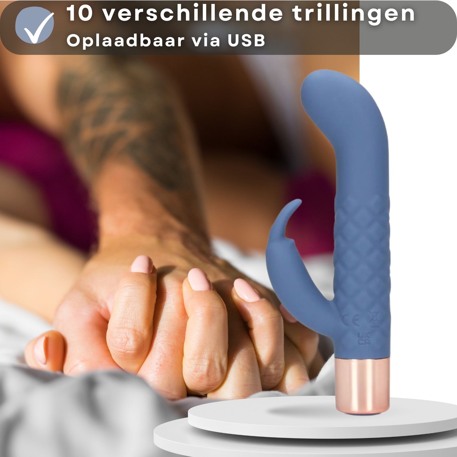 Blauwe vibrator met roségouden basis. Handen vasthouden. Product op sokkel.